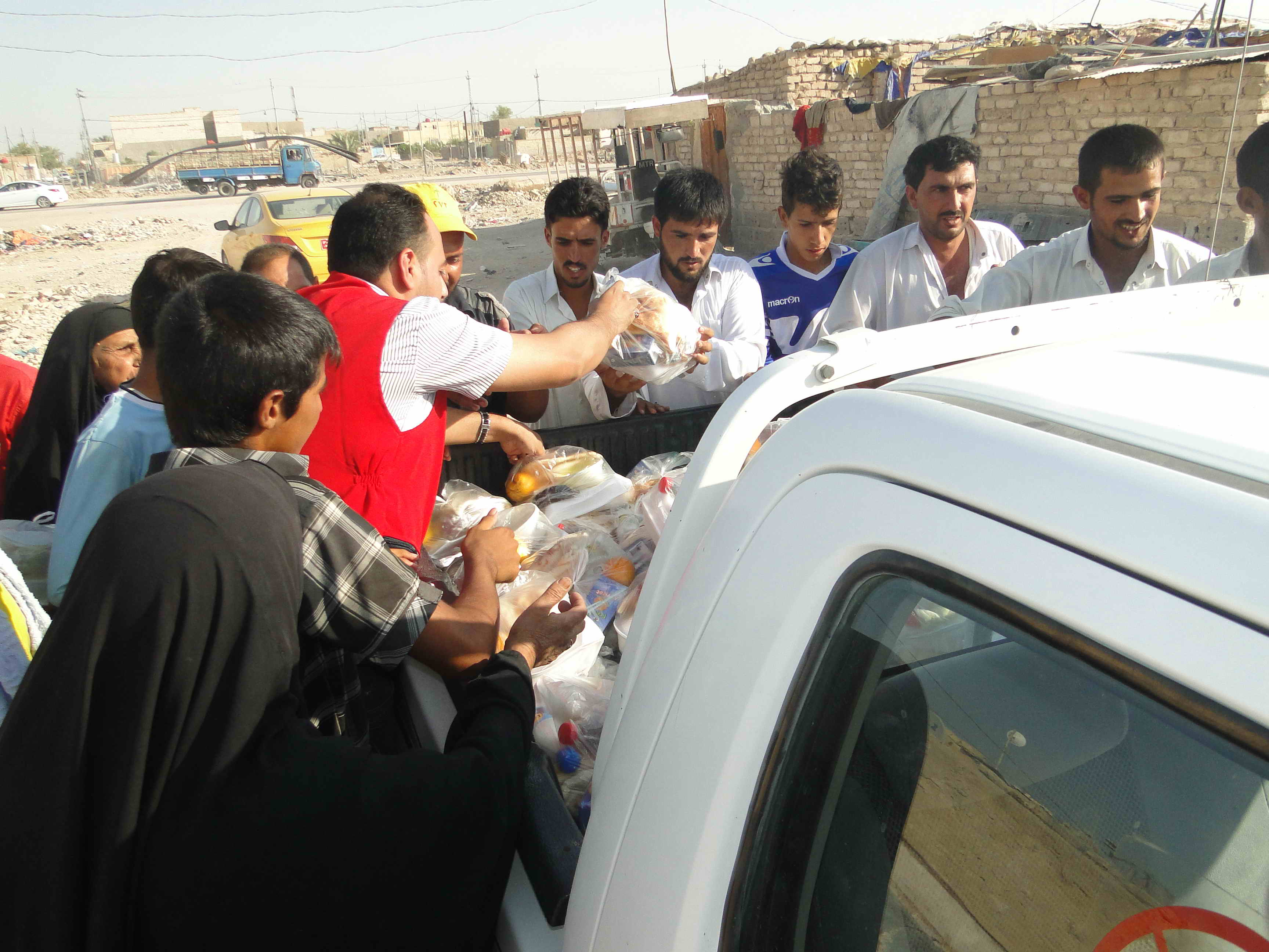 فرق الهلال الاحمر العراقي تقوم بتوزيع السلات الغذائية و وجبات الافطار للنازحين في النجف الاشرف وديالى